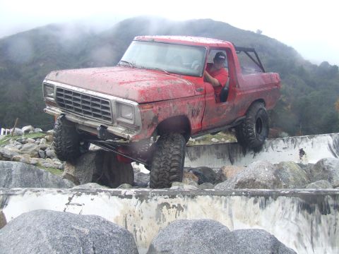 1978 Ford Bronco - A red 1978 Ford Bronco navigates a rocky obstacle course, demonstrating its off-road capabilities.