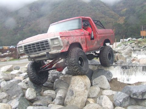 1978 Ford Bronco - Red 1978 Ford Bronco navigating a challenging rocky terrain.