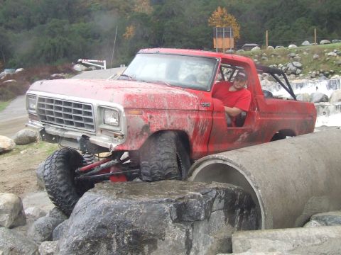 1978 Ford Bronco - This red 1978 Ford Bronco is navigating a challenging off-road course with large rocks and a concrete culvert.