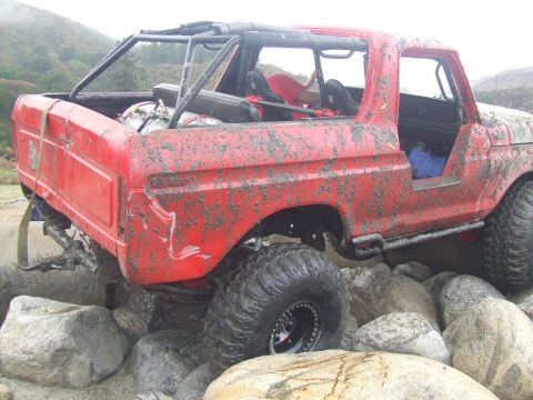 1978 Ford Bronco - This heavily modified SUV is navigating a rocky obstacle course.