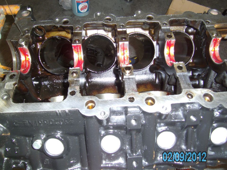 Engine block with crankshaft bearings visible, part of an engine overhaul