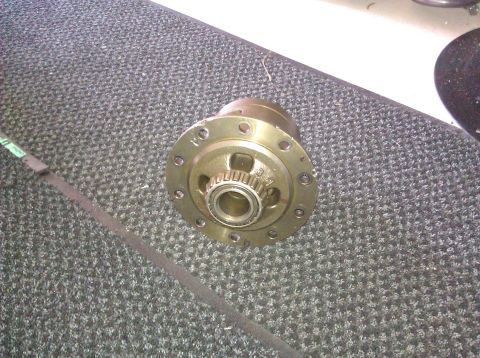 1995 Ford Bronco - A close-up view of a differential carrier part resting on a textured surface.