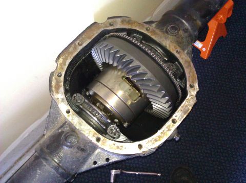 1995 Ford Bronco - Close-up of an open differential housing, revealing internal gears and a tool on the floor.