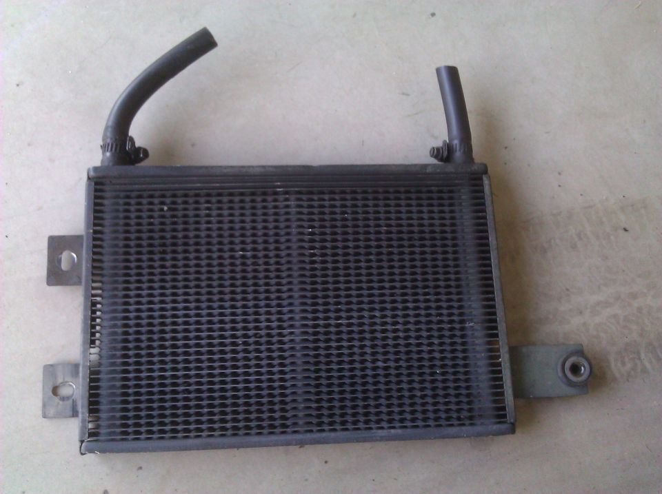 Radiator with two hoses attached, metal mounting brackets visible