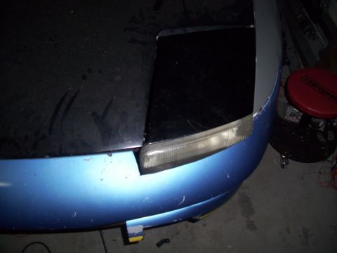 1995 Ford Probe - The front corner of a car is shown, with a blue bumper and a black hood section.
