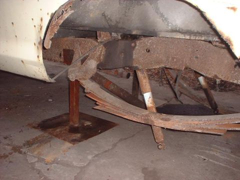 1993 Ford Bronco - Close-up of heavily rusted leaf springs and vehicle frame components.