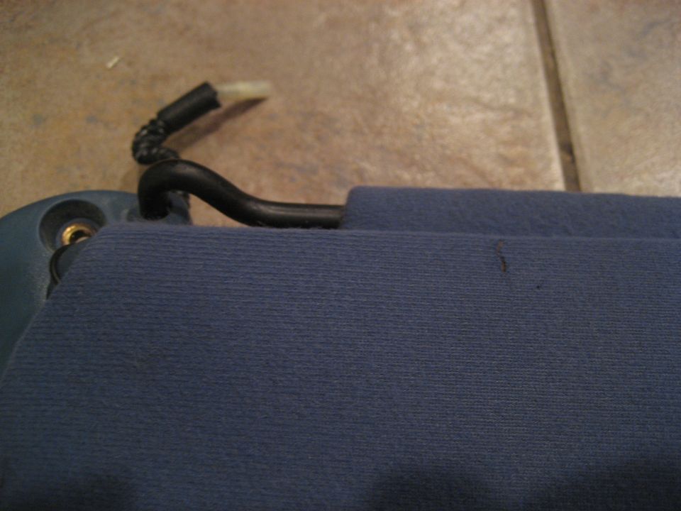 Close-up of a blue car sun visor with a black plastic clip and mounting bracket