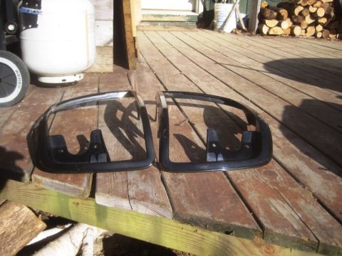 1993 Ford Bronco - Two black headlight bezels are displayed on a wooden deck.