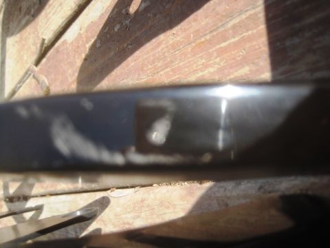 1993 Ford Bronco - Close-up of a dark car part, possibly a trim piece, showing wear.