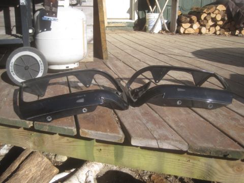 1993 Ford Bronco - Two black car fender pieces are laid out on a wooden deck next to a propane tank and a grill.