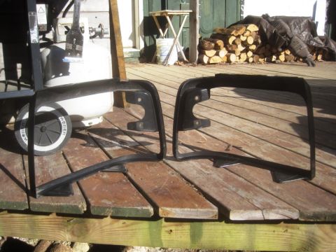 1993 Ford Bronco - Two black plastic bumper trim pieces are displayed on a wooden deck, with a propane tank and grill visible.