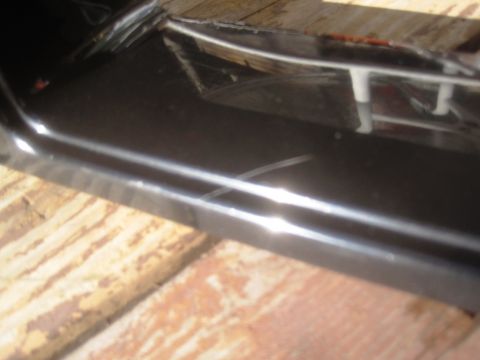 1993 Ford Bronco - Close-up of a scratched black car panel with visible white trim and a Supermotors.net watermark.