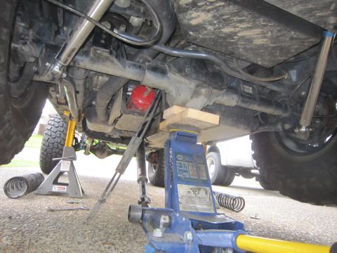 2008 Jeep Wrangler - Vehicle undercarriage with suspension components visible, supported by jack stands and a hydraulic jack.