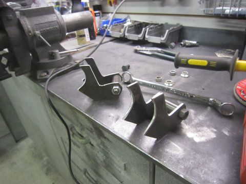 2008 Jeep Wrangler - Metal brackets and tools are laid out on a workbench, ready for assembly or fabrication.