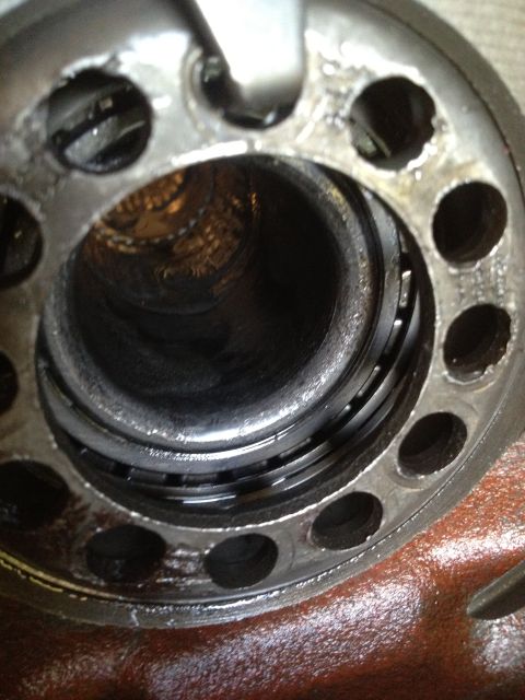 1979 Ford Bronco - Close-up of a worn bearing race inside a metal housing, showing signs of damage.