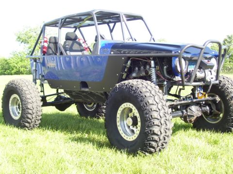 1967 Ford Mustang - This custom-built buggy features a prominent roll cage and oversized off-road tires, suggesting it is not a standard production vehicle.