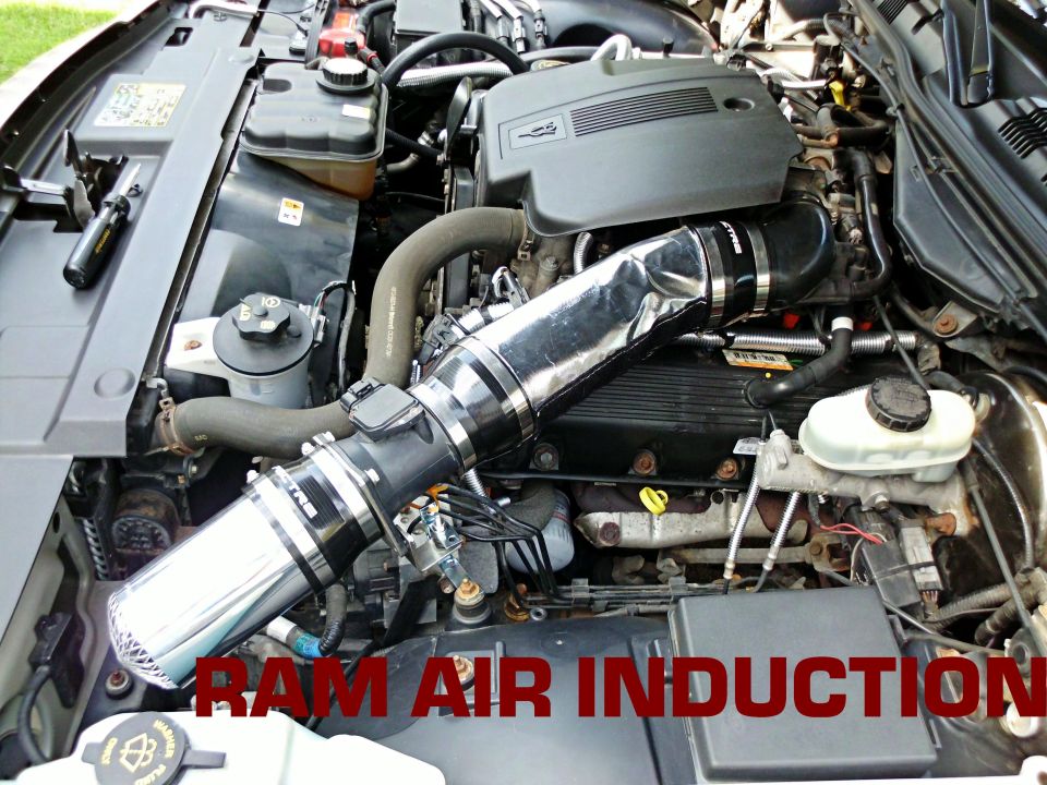 Engine bay with polished chrome cold air intake and 'RAM AIR INDUCTION' text overlay