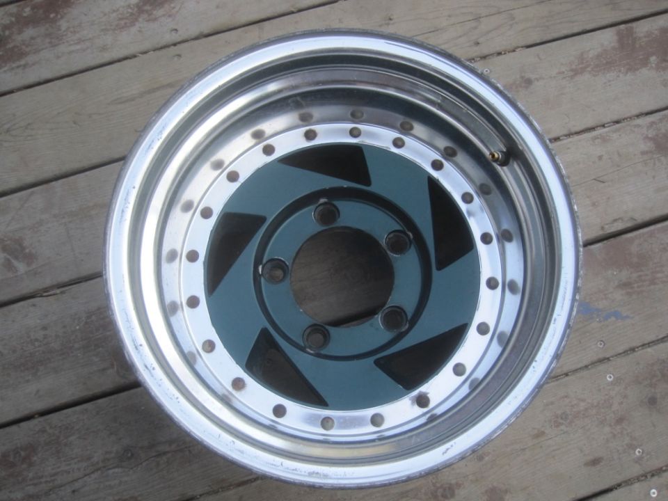 Chrome and teal custom wheel with five lug nuts