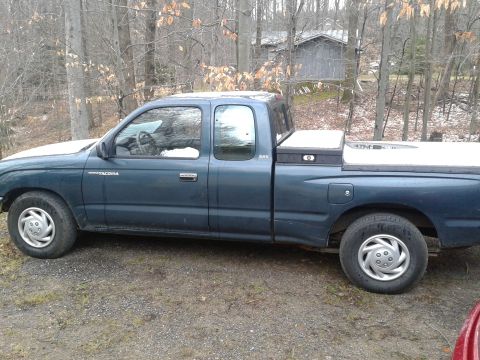 1978 Ford F-150 - Side view of a blue Toyota Tacoma pickup truck with a toolbox in the bed.