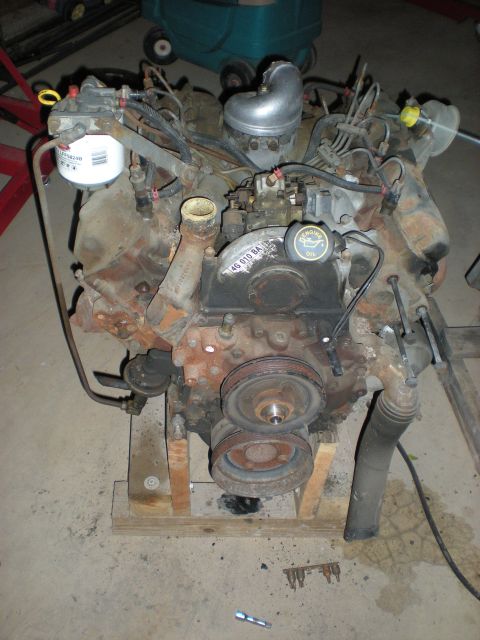 1986 Ford Bronco - This engine is mounted on a wooden stand and appears to be a diesel engine.