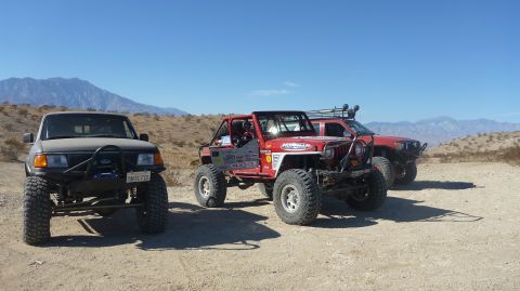 1997 Ford Ranger - A modified 1997 Ford Ranger is parked in a desert landscape alongside other off-road vehicles.