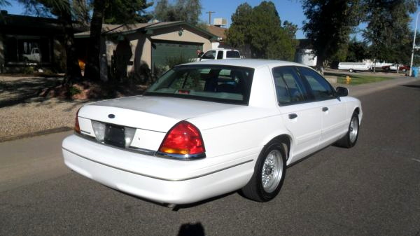 White 2001 Ford Crown Victoria, rear quarter view, parked on asphalt street