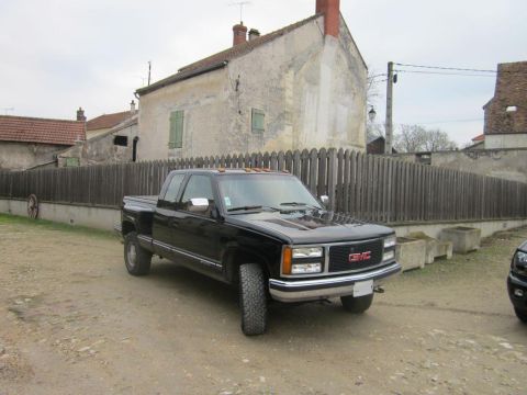 1991 Ford LTD Crown Victoria - This black GMC pickup truck is shown from a 3/4 front angle, with its grille suggesting a 1995 model year.
