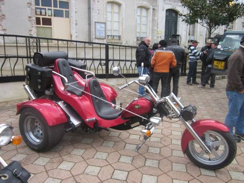1991 Ford LTD Crown Victoria - A red trike motorcycle is parked outside a building with several people standing nearby.