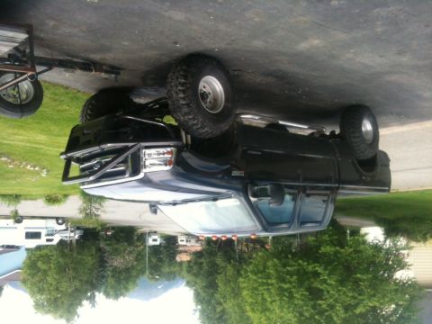 1990 Chevrolet Suburban - This black pickup truck has a distinctive grille and bumper, suggesting a model year around 2000.