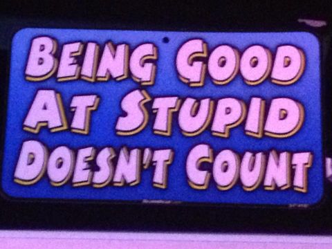 1976 Ford Bronco - A humorous sign with a blue background and pink lettering states 'BEING GOOD AT STUPID DOESN'T COUNT'.
