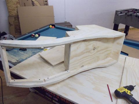 1985 Ford Bronco - A wooden frame is being constructed on top of a pool table, with a foosball table visible in the background.