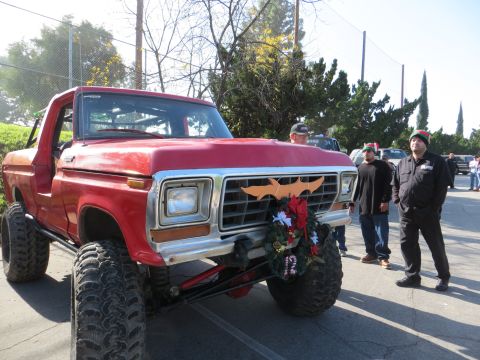 1978 Ford Bronco - A red Ford Bronco, modified with a lift kit, is decorated with a holiday wreath for a festive occasion.