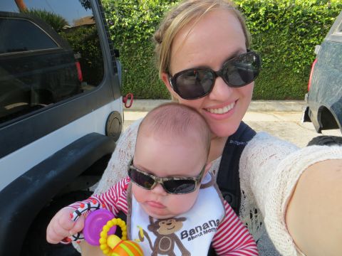 1978 Ford Bronco - A woman and a baby, both sporting sunglasses, pose for a selfie with a black Jeep in the background.