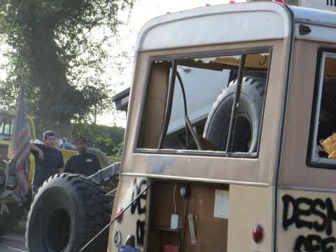 1978 Ford Bronco - Modified van with graffiti and large tires, two men standing nearby. A spare tire is visible inside.