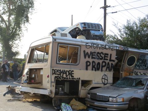 1978 Ford Bronco - A heavily modified camper van, covered in graffiti, with another vehicle precariously balanced on its roof.