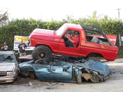 1978 Ford Bronco - A red 1978 Ford Bronco is shown crushing a blue sedan, demonstrating its off-road capabilities.