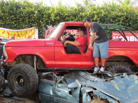 1978 Ford Bronco - This 1978 Ford Bronco is crushing a car, with two people posing in and around it.