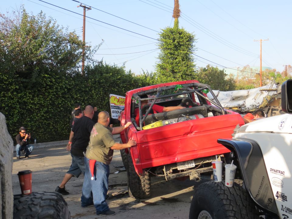Red off-road vehicle with roll cage, rear view. Two cups on tire
