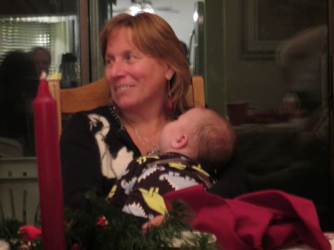 1978 Ford Bronco - A woman holds a sleeping baby indoors, with a red candle and festive greenery visible.