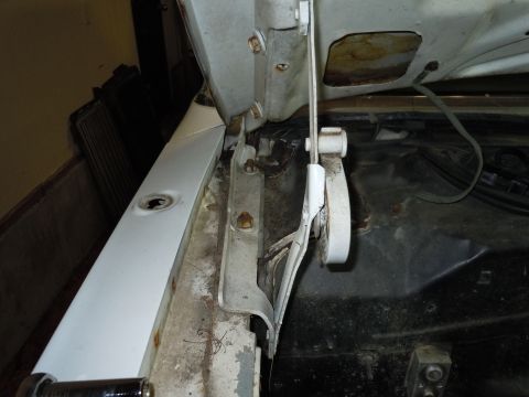 2001 Ford Crown Victoria - The photo shows the internal mechanism of a car's hood hinge, with visible rust and wear.