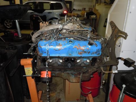2001 Ford Crown Victoria - A V8 engine, likely out of a car, is mounted on an engine stand in a workshop.