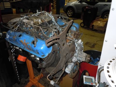 2001 Ford Crown Victoria - Engine assembly with blue valve covers and attached metal chains, supported by an orange engine stand.