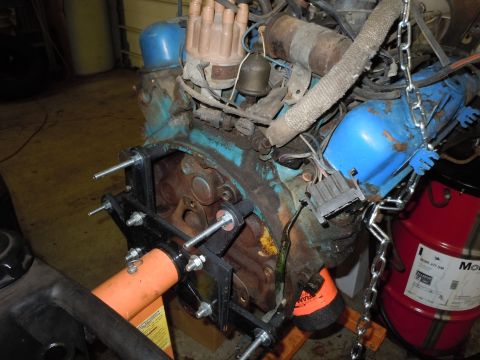 2001 Ford Crown Victoria - Engine assembly on a stand, blue valve covers and a red oil drum in the background.