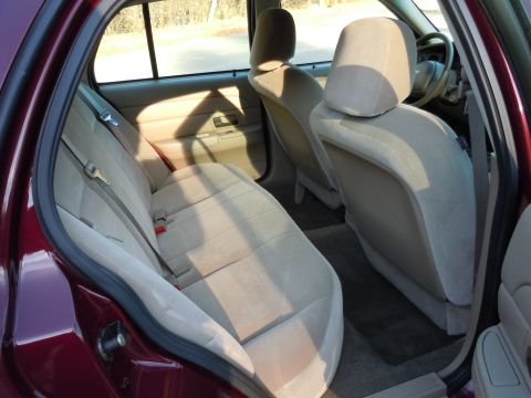 2001 Ford Crown Victoria - Interior view of a maroon 2001 Ford Crown Victoria, highlighting the tan cloth seating and interior trim.