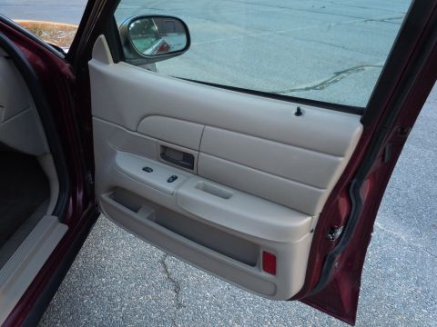 2001 Ford Crown Victoria - The interior door panel of a 2001 Ford Crown Victoria, tan upholstery and maroon trim.