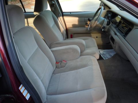 2001 Ford Crown Victoria - The interior of a 2001 Ford Crown Victoria features cloth bucket seats with armrests and a clean dashboard.