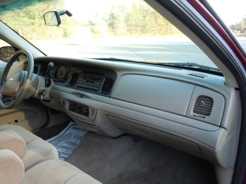 2001 Ford Crown Victoria - The interior of a 2001 Ford Crown Victoria is visible from the passenger side, with a clear view of the dashboard and steering wheel.