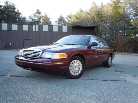 2001 Ford Crown Victoria - Maroon 2001 Ford Crown Victoria parked on asphalt in front of a commercial building.