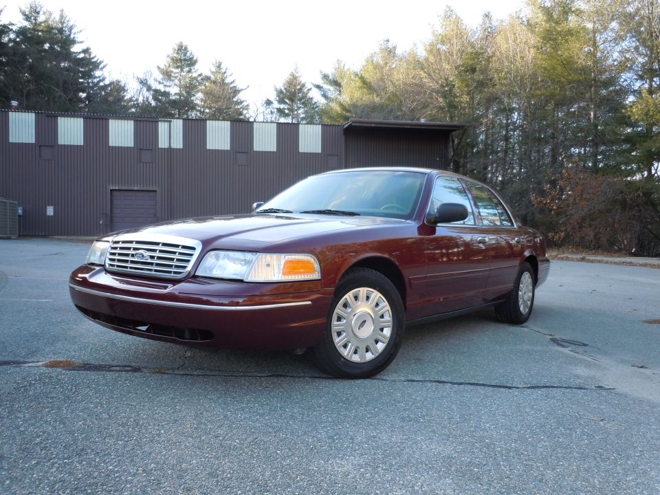 Maroon 2001 Ford Crown Victoria parked outside a building