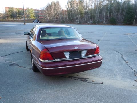2001 Ford Crown Victoria - Rear view of a maroon 2001 Ford Crown Victoria parked in an empty lot.